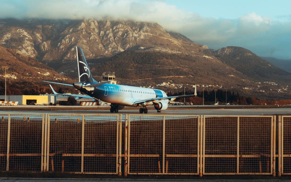 A plane on the runway at Tivat Airport, ringed by mountains